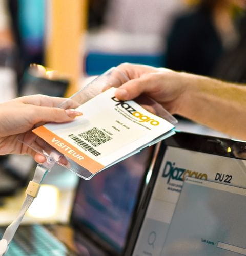 Close-up of a Djazagro trade show visitor badge, handed over at the entrance during registration.