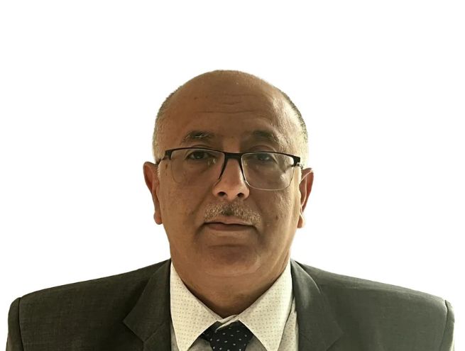 Portrait of Zaki Hariz wearing a suit and tie, against a white background.