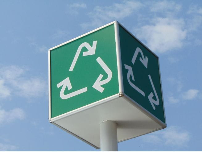 Panneau vert avec le symbole du recyclage sur un fond de ciel bleu
