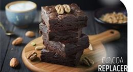 Brownies au cacao de substitution empilés sur une planche en bois, décorés de noix.