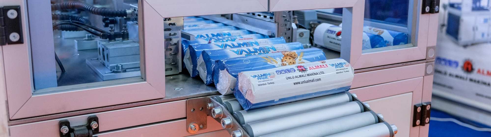Industrial machine packaging biscuit packs on an automated production line in a food processing factory