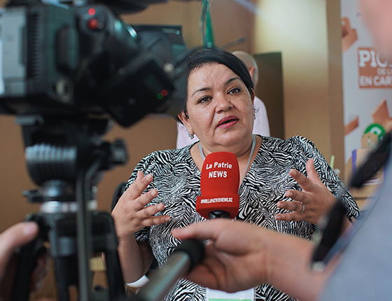 Woman speaking into a microphone in front of a camera